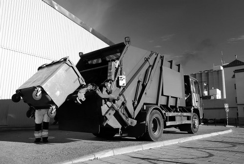 Office exterior with commercial waste bins and service vehicle arriving