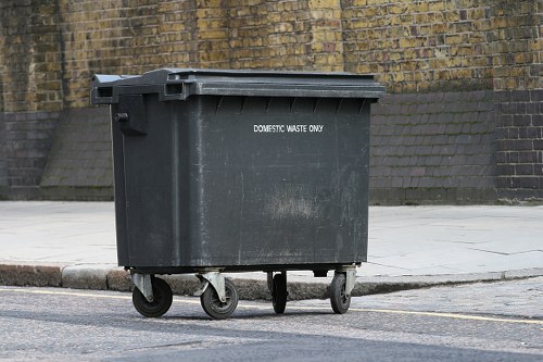 Investigator inspecting waste container at a commercial premises
